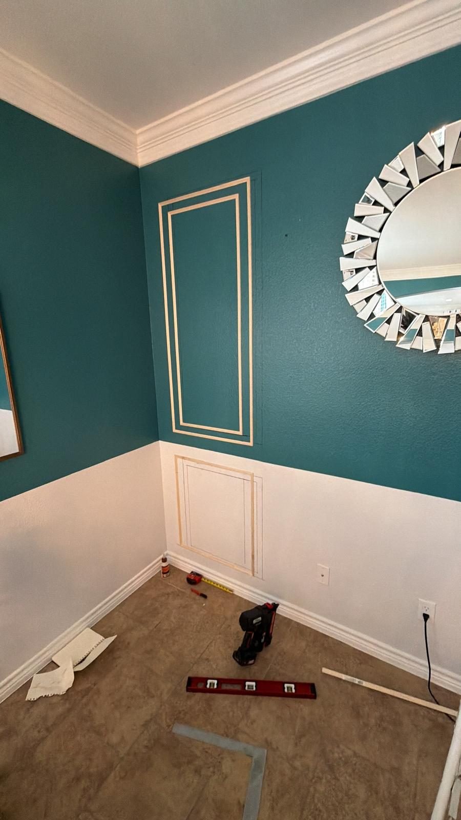 Decorative trim on teal wall in progress